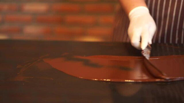 People making brown chocolates on the marble table