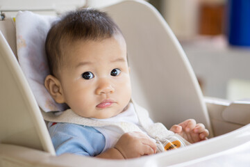 6 months old Asian baby eating food