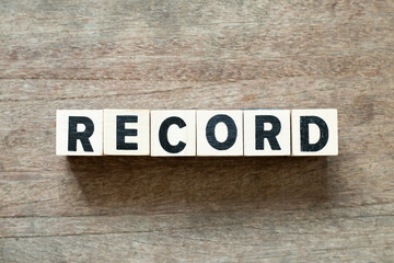 Alphabet letter block in word record on wood background