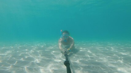 Underwater selfie taken by an athletic Caucasian male who is a great swimmer. Freediving and relaxation concept by the sea or ocean