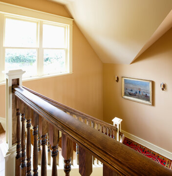 Traditional staircase of house with window and portrait.