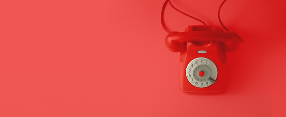 A red vintage dial telephone with red background.