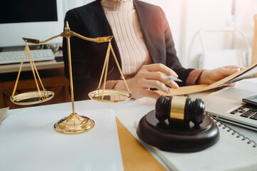 Business and lawyers discussing contract papers with brass scale on desk in office. Law, legal services, advice, justice and law concept picture with film grain effect