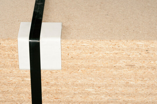 Wooden block with tape and bumper block to protect corner.