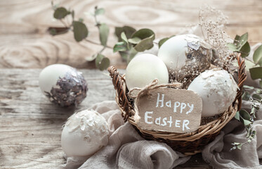 Easter composition with decorative eggs in a basket on a wooden table.