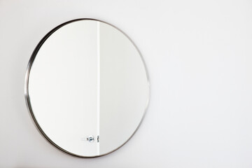 Bathroom mirror on a white wall.