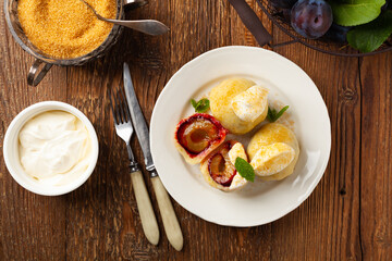 Dumplings with plums, topped with plum sauce or served with cream and sugar.