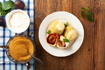 Dumplings with plums, topped with plum sauce or served with cream and sugar.