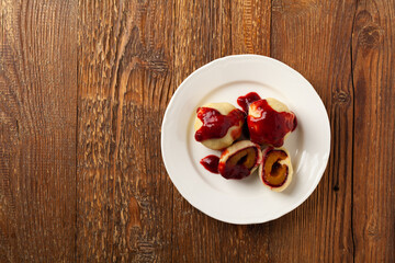 Dumplings with plums, topped with plum sauce or served with cream and sugar.