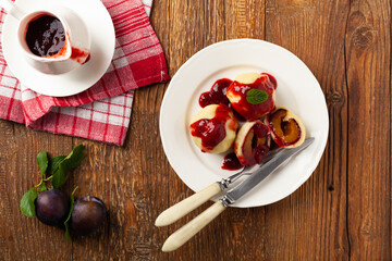 Dumplings with plums, topped with plum sauce or served with cream and sugar.