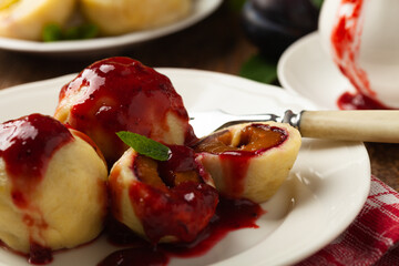 Dumplings with plums, topped with plum sauce or served with cream and sugar.