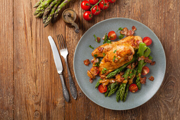 Roasted chicken breast, served on asparagus with tomato sauce, dried tomatoes. Top view.