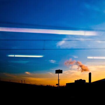 Fototapeta Factory seen through car window at sunset.