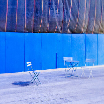 Folding chairs in front of construction site hoarding.