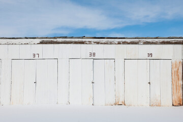 Nimbered doors on corrugated metal storage building.