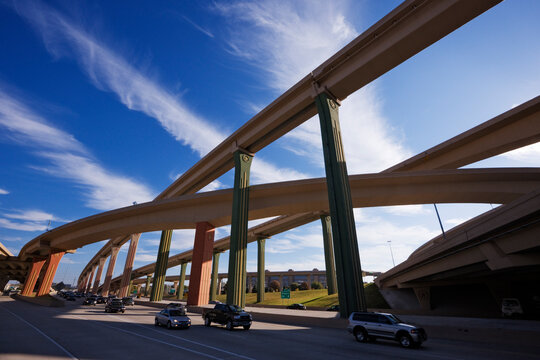 Cars on a highway with elevated roads above.