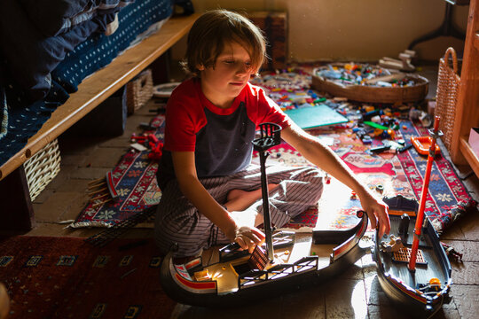 Overhead view of young boy in his room playing with his toys
