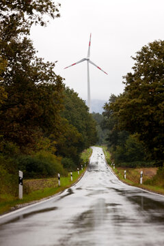 Wind turbine and wet straight road nr Trier, in the Moselle wine region, Germany