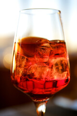 Close upof a glass with ice and orange coctail in restaurant.
