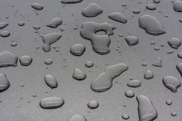 Drops of water on gray metallic surface.