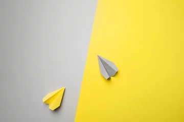 Trendfotografie zum Thema der neuen Farbe des Jahres 2021: Ultimate Grey und Illuminating. gelbe und graue flugzeuge auf dem hintergrund mit kopienraum © Natalia