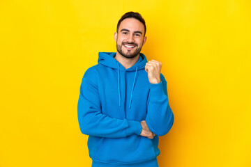 Young caucasian handsome man isolated on yellow background laughing