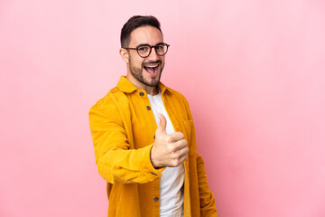 Young caucasian handsome man isolated on pink background with thumbs up because something good has happened