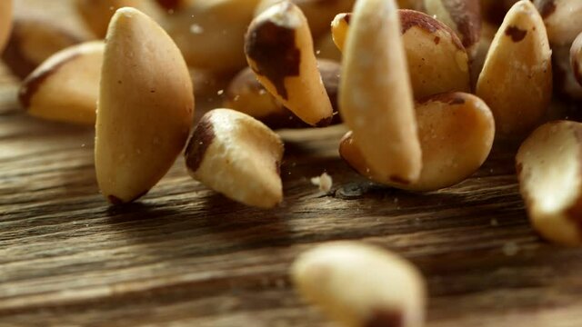 Brazil Nuts Falling on Vintage Wooden Table. Super Slow Motion.