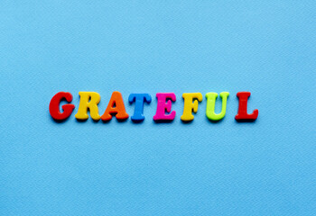 word grateful on blue paper background