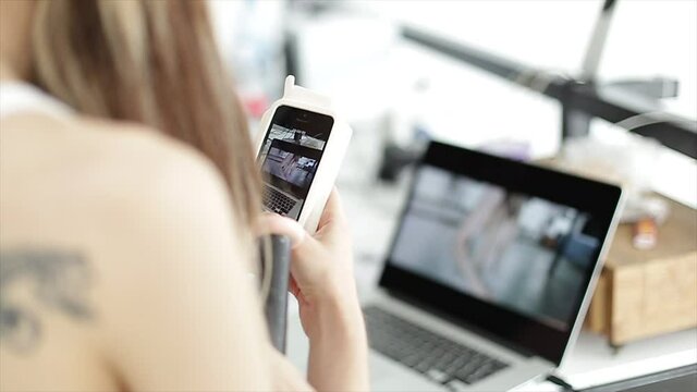 Osoba pracująca przy laptopie i z pomocą telefonu, montaż video, jasne ujęcie pełne światła.