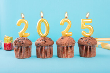 2025 Number gold candle on a cupcake against a pastel blue background two thousand and twenty five year celebration