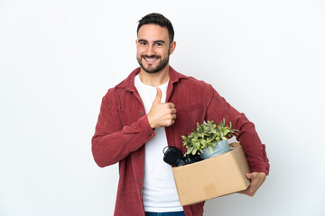 Young caucasian man making a move while picking up a box full of things isolated on white...