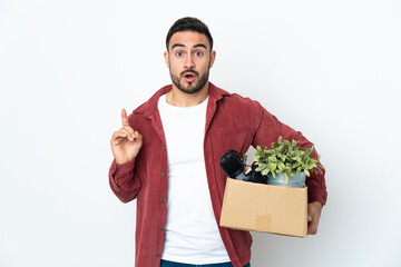 Young caucasian man making a move while picking up a box full of things isolated on white...