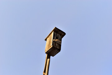 Wooden birdhouse against the white sky in the village