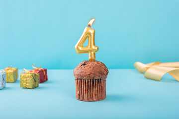 4 Number gold candle on a cupcake against a pastel blue background four year celebration 