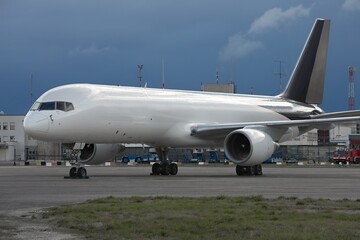 Fototapeta na wymiar Cargo freighter airplane parked at an airport, blank white body