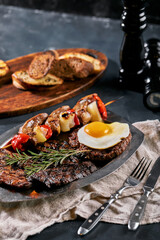 Grilled meat platter. Assorted delicious grilled meat with vegetables. Grilled mixed meat with pepper sauce and vegetables. Chef's hands spread meat on a plate