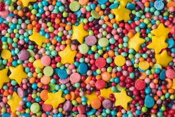 Fototapeta na wymiar Close up above view photo of multicolored in different shape figures sugar sprinkles textured background