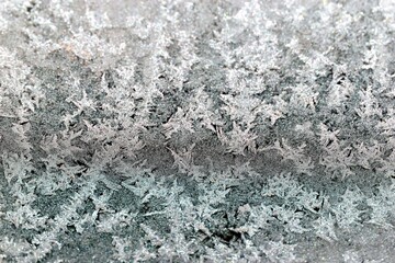 Glass covered with patterns and crystals of frost in winter