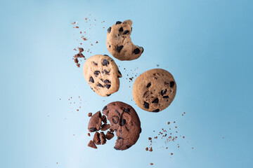 Four chocolate chip cookies flying on a blue background.