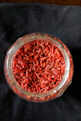 Jagody goji w dużym szklanym słoju na ciemnym tle © Miroslaw