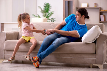 Obraz premium Young man with his daughter at home