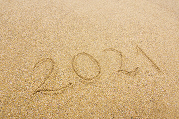 Fototapeta na wymiar 2021 handwritten on beach sand, new year and holiday concept