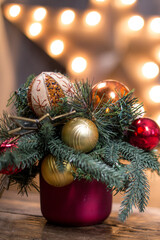 The New Year's little tree with Christmas toys at the table. Christmas tree and bokeh lights of the big star. Сhristmas ball and snowflake hanging on the tree. Decorated christmas tree.