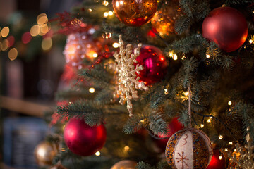 The New Year's tree with gifts and Christmas toys. Christmas tree and bokeh lights. Сhristmas ball and snowflake hanging on the tree. Decorated christmas tree.