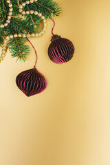 Christmas decorations with a spruce branches on a golden background. Christmas wallpaper or postcard concept.