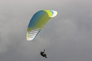 Paraglider flying wing in a cloudy sky	