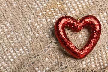 a red heart shape on wool textile background - new year or holiday decoration