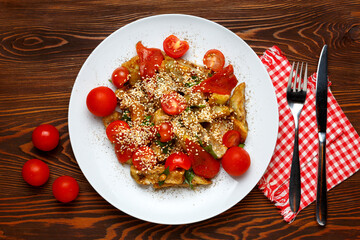 Warm eggplant salad garnished with sesame seeds and sherry tomatoes