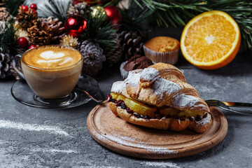 Fototapeta na wymiar New Year's breakfast with croissants. New Year's croissant with chocolate and baked orange
